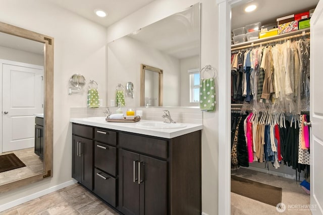 6451 Randolph Dr NE, Bremerton, WA 98311 - bathroom with double vanity, tasteful backsplash, a spacious closet, and baseboards