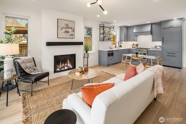 6707 117th Ave NE, Kirkland, WA 98033 - living room with light wood-type flooring, a warm lit fireplace, recessed lighting, and baseboards