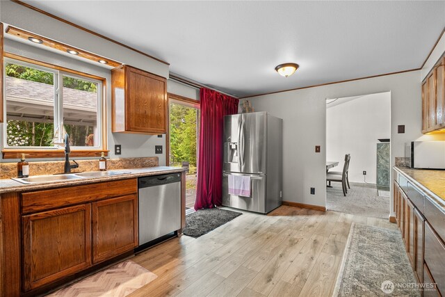 37911 300th Ave SE, Enumclaw, WA 98022 - kitchen with stainless steel appliances, a sink, brown cabinetry, light wood finished floors, and crown molding