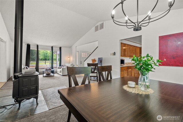 37911 300th Ave SE, Enumclaw, WA 98022 - carpeted dining area with lofted ceiling, a chandelier, and a wood stove