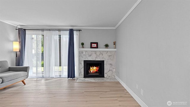 323 128th St SE Unit K120, Everett, WA 98208 - living area featuring crown molding, wood finished floors, a high end fireplace, and baseboards