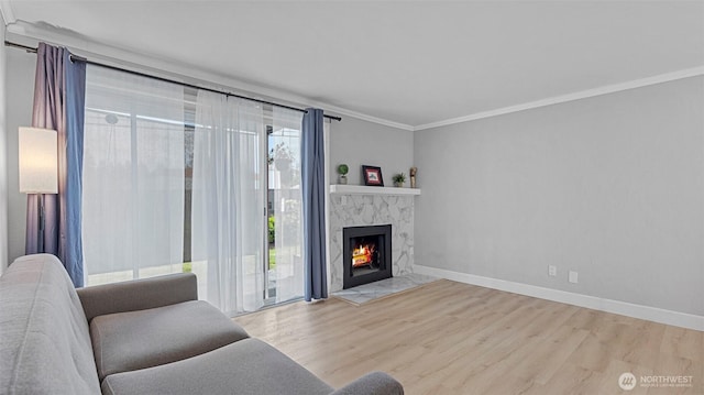 323 128th St SE Unit K120, Everett, WA 98208 - living area featuring crown molding, wood finished floors, a fireplace, and baseboards