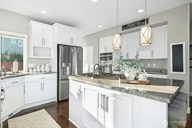 23510 14th Dr SE, Bothell, WA 98021 - kitchen featuring appliances with stainless steel finishes, a kitchen island, light stone countertops, white cabinetry, and recessed lighting