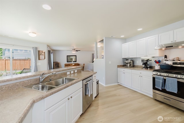 2760 SW Jabirin Way, Port Orchard, WA 98367 - kitchen with stainless steel appliances, under cabinet range hood, a sink, white cabinetry, and recessed lighting