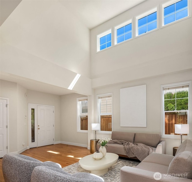 27332 SE 10th Ct, Sammamish, WA 98075 - living room with light wood-type flooring, healthy amount of natural light, a high ceiling, and baseboards