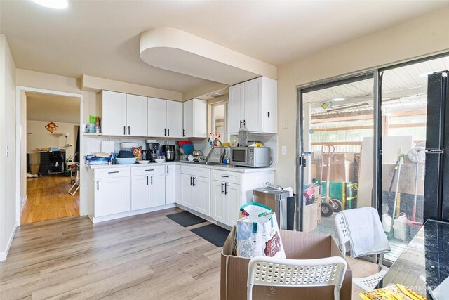 7919 37th Ave S, Seattle, WA 98118 - kitchen featuring white microwave, light wood-style floors, and white cabinets