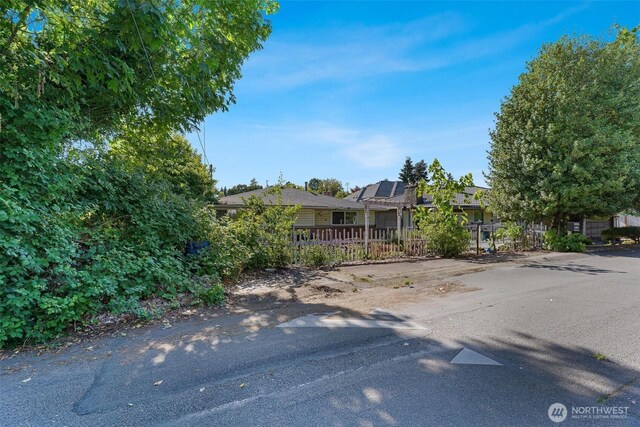 7919 37th Ave S, Seattle, WA 98118 - view of property hidden behind natural elements featuring roof mounted solar panels