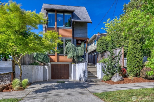 2334 N 57th St, Seattle, WA 98103 - modern home with concrete driveway, stairway, and a shingled roof