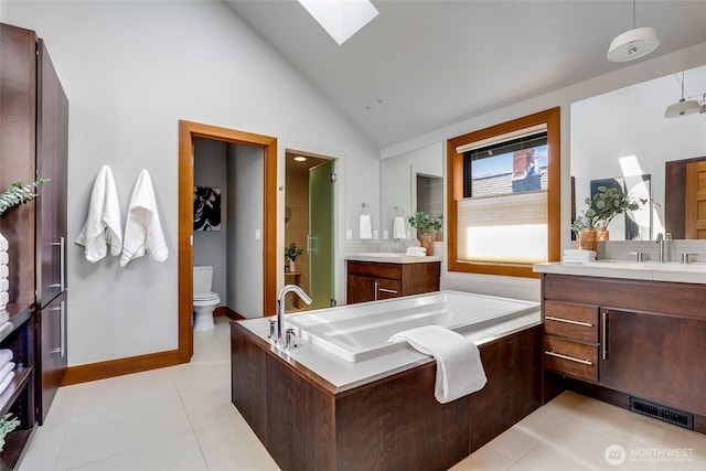 2334 N 57th St, Seattle, WA 98103 - bathroom with a skylight, vaulted ceiling, two vanities, a garden tub, and toilet