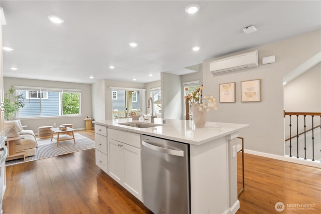 6730 34th Ave SW, Seattle, WA 98126 - kitchen with stainless steel dishwasher, a wall mounted air conditioner, a sink, open floor plan, and hardwood / wood-style floors