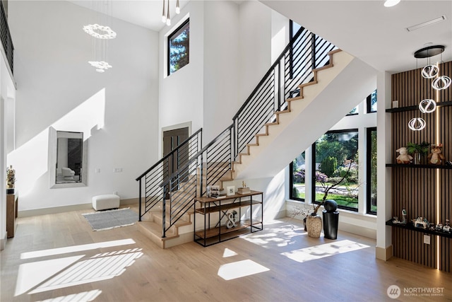 8456 SE 40th St, Mercer Island, WA 98040 - stairway featuring a chandelier, a high ceiling, wood finished floors, and baseboards