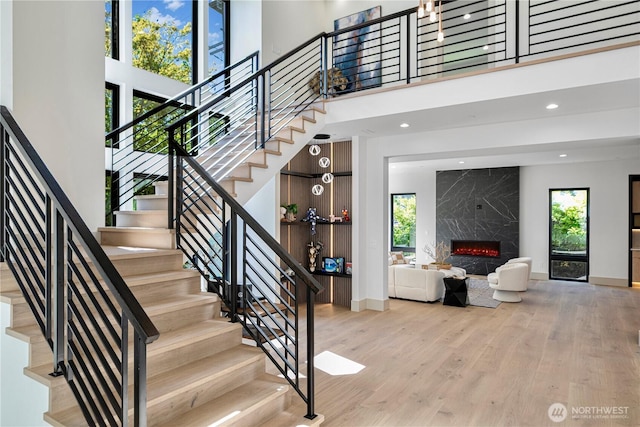 8456 SE 40th St, Mercer Island, WA 98040 - stairway featuring baseboards, a high ceiling, wood finished floors, a fireplace, and recessed lighting