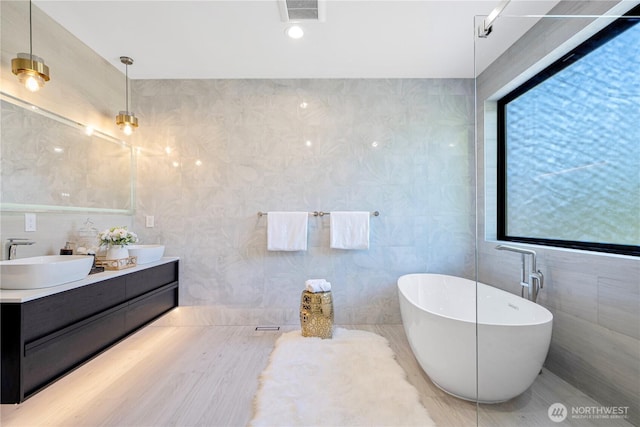 8456 SE 40th St, Mercer Island, WA 98040 - bathroom featuring tile walls, double vanity, and a freestanding bath