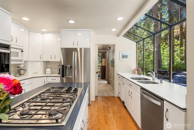 2911 216th Ave NE, Sammamish, WA 98074 - kitchen with stainless steel appliances, a sink, light wood-style flooring, light countertops, and white cabinets