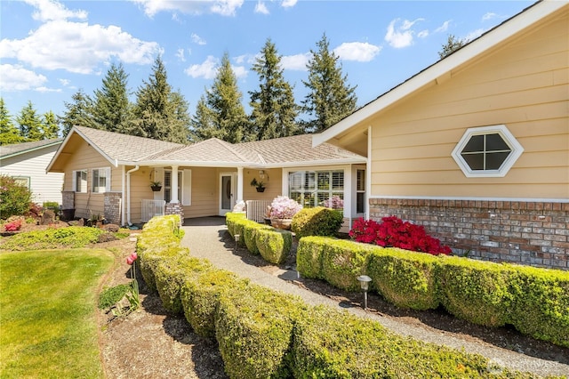 6888 Golf View Dr, Lynden, WA 98264 - view of front of property featuring covered porch, brick siding, a shingled roof, and a front lawn