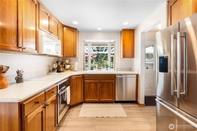 6888 Golf View Dr, Lynden, WA 98264 - kitchen featuring stainless steel appliances, a sink, light wood-style flooring, light countertops, and recessed lighting