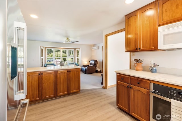 6888 Golf View Dr, Lynden, WA 98264 - kitchen with white microwave, stainless steel oven, light wood-style floors, light countertops, and open floor plan