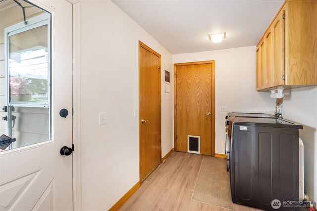 6888 Golf View Dr, Lynden, WA 98264 - laundry room with cabinet space, light wood-type flooring, and baseboards