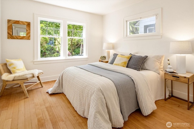 4828 38th Ave NE, Seattle, WA 98105 - bedroom featuring multiple windows, light wood-style floors, and baseboards