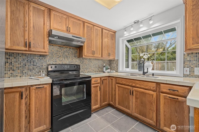 325 NE 178th St, Shoreline, WA 98155 - kitchen with under cabinet range hood, electric range, a sink, light tile patterned floors, and tile counters