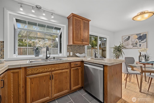325 NE 178th St, Shoreline, WA 98155 - kitchen featuring stainless steel dishwasher, a sink, brown cabinetry, tile countertops, and a peninsula