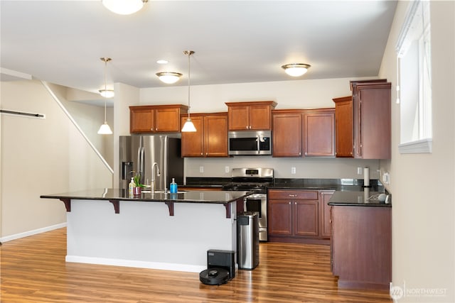 7609 Columbia Way NE, Lacey, WA 98516 - kitchen with stainless steel appliances, a kitchen breakfast bar, wood finished floors, and pendant lighting