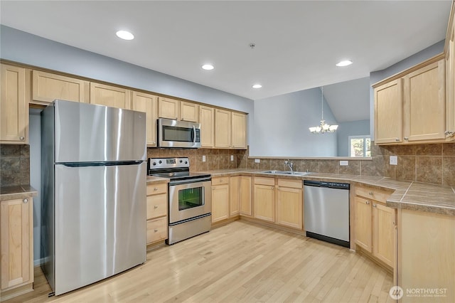5909 Panorama Dr SE Unit 6-103, Auburn, WA 98092 - kitchen with stainless steel appliances, light brown cabinetry, tasteful backsplash, light wood-type flooring, and a chandelier