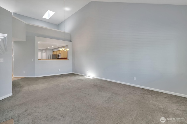 5909 Panorama Dr SE Unit 6-103, Auburn, WA 98092 - unfurnished living room featuring a skylight, a chandelier, baseboards, carpet, and high vaulted ceiling