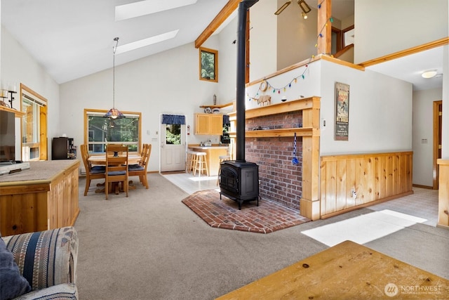 7101 Rainier Way, Glacier, WA 98244 - living room featuring light colored carpet, a wood stove, high vaulted ceiling, and a skylight