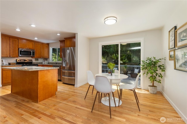 19802 33rd Dr SE, Bothell, WA 98012 - kitchen with appliances with stainless steel finishes, brown cabinets, a center island, light wood-style floors, and recessed lighting
