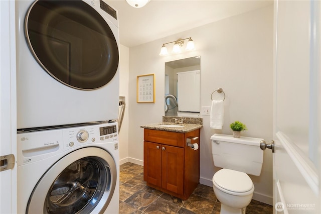 19802 33rd Dr SE, Bothell, WA 98012 - half bathroom with estacked washer and dryer, vanity, toilet, baseboards, and stone finish floors