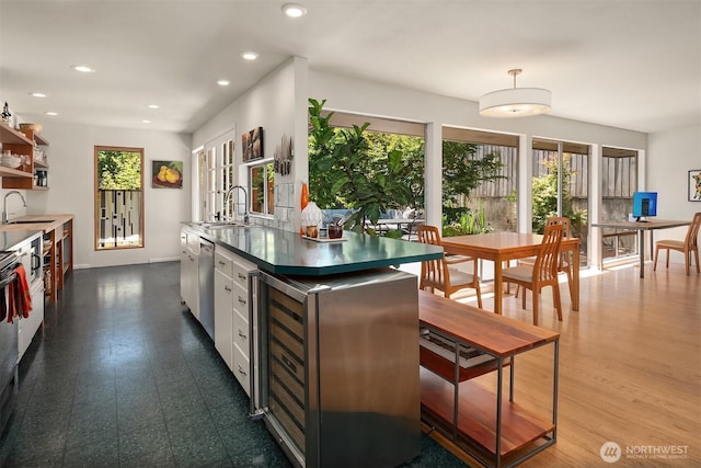 2043 N 78th St, Seattle, WA 98103 - kitchen featuring stainless steel dishwasher, a sink, recessed lighting, open shelves, and white cabinets
