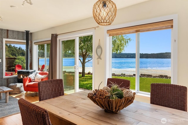 24410 Vashon Hwy SW, Vashon, WA 98070 - dining space with a wood stove, wood finished floors, and a water view