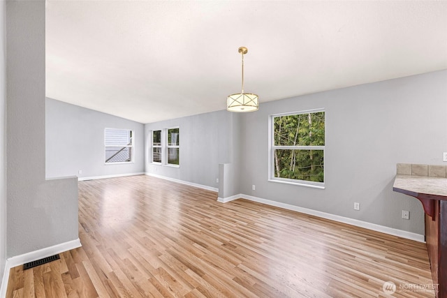 4949 Samish Way Unit 17, Bellingham, WA 98229 - unfurnished living room with light wood-style flooring, baseboards, and lofted ceiling