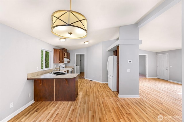 4949 Samish Way Unit 17, Bellingham, WA 98229 - kitchen featuring white appliances, a sink, light countertops, light wood-style flooring, and a peninsula