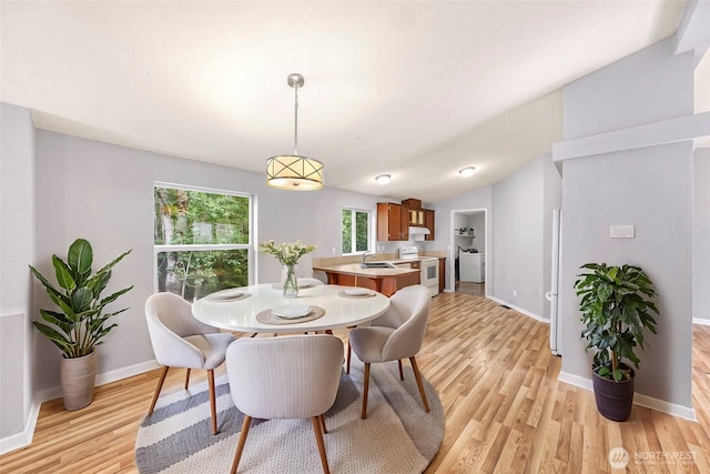 4949 Samish Way Unit 17, Bellingham, WA 98229 - dining area with light wood-style floors, washer / clothes dryer, baseboards, and vaulted ceiling