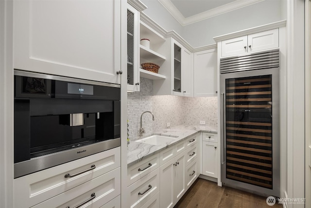 1848 77th Ave NE, Medina, WA 98039 - kitchen featuring wine cooler, a sink, ornamental molding, white cabinetry, and glass insert cabinets
