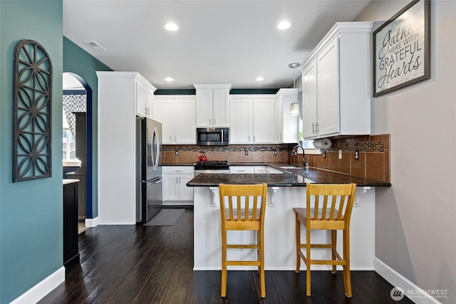 22306 137th Ave E, Graham, WA 98338 - kitchen with appliances with stainless steel finishes, a sink, a peninsula, white cabinetry, and backsplash