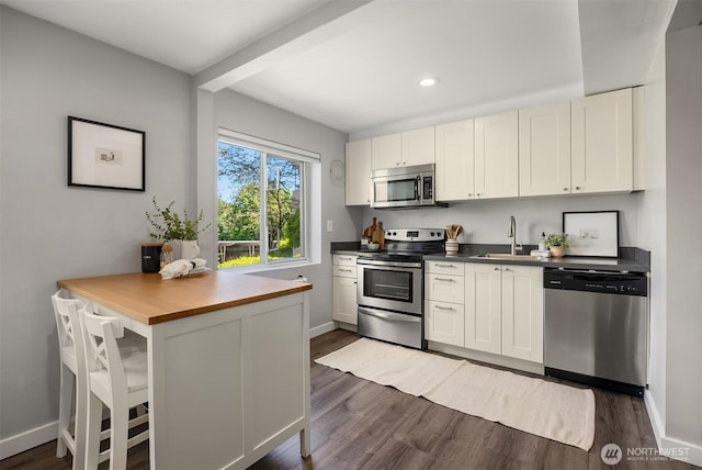 1800 Taylor Ave N Unit 1, Seattle, WA 98109 - kitchen featuring stainless steel appliances, a sink, dark wood-style flooring, baseboards, and recessed lighting