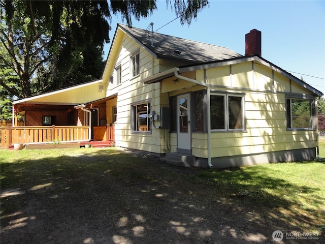 1242 Lidstrom Rd E, Port Orchard, WA 98366 - view of side of home featuring a chimney, a yard, covered porch, and a shingled roof