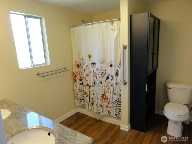 1242 Lidstrom Rd E, Port Orchard, WA 98366 - full bath with wood finished floors, double vanity, toilet, baseboards, and curtained shower