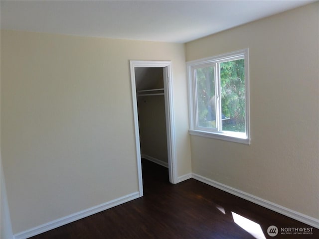 1242 Lidstrom Rd E, Port Orchard, WA 98366 - unfurnished bedroom featuring dark wood-type flooring, baseboards, a walk in closet, and a closet