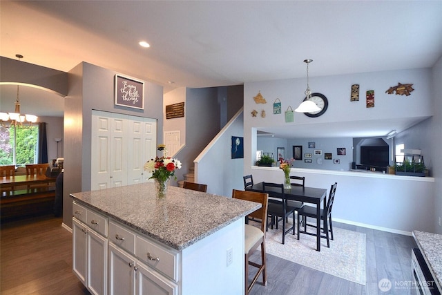 15437 104th Way SE, Yelm, WA 98597 - kitchen featuring dark wood finished floors, a chandelier, white cabinetry, a kitchen bar, and a center island