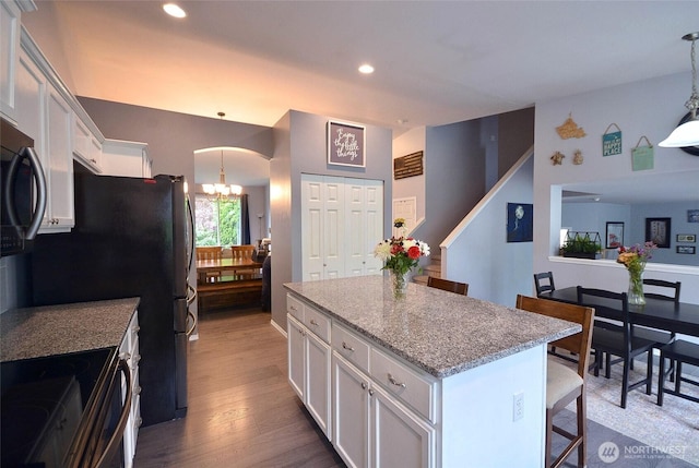 15437 104th Way SE, Yelm, WA 98597 - kitchen featuring white cabinets, stainless steel electric range oven, a center island, a chandelier, and a kitchen bar