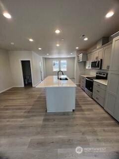 12080 127th Avenue Ct E Unit 73, Puyallup, WA 98374 - kitchen with appliances with stainless steel finishes, recessed lighting, an island with sink, wood finished floors, and light countertops