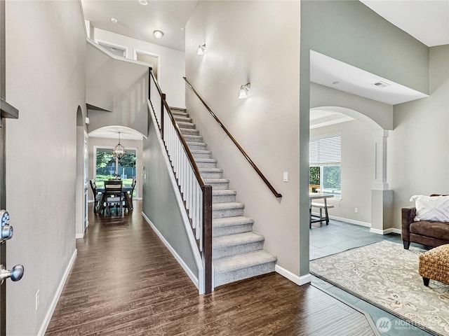 4339 S 160th St, Tukwila, WA 98188 - staircase with arched walkways, wood finished floors, and a high ceiling