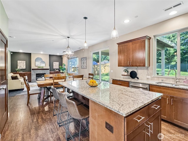 4339 S 160th St, Tukwila, WA 98188 - kitchen featuring wood finished floors, a center island, recessed lighting, light stone counters, and a kitchen breakfast bar