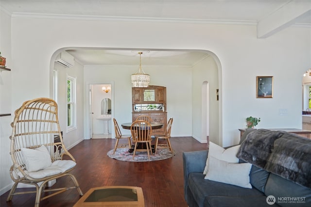 5060 E State Route 106, Union, WA 98592 - living room with arched walkways, crown molding, wood finished floors, an AC wall unit, and baseboards