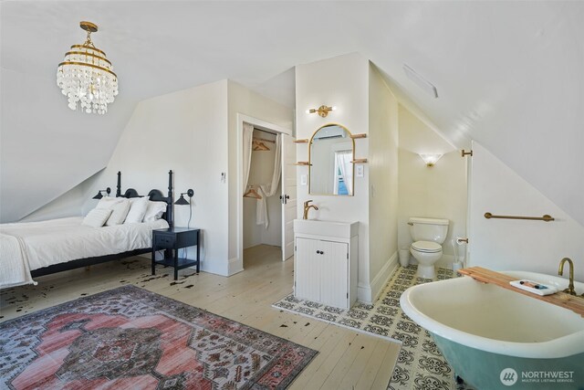 5060 E State Route 106, Union, WA 98592 - bathroom featuring vaulted ceiling, wood-type flooring, vanity, a freestanding tub, and baseboards