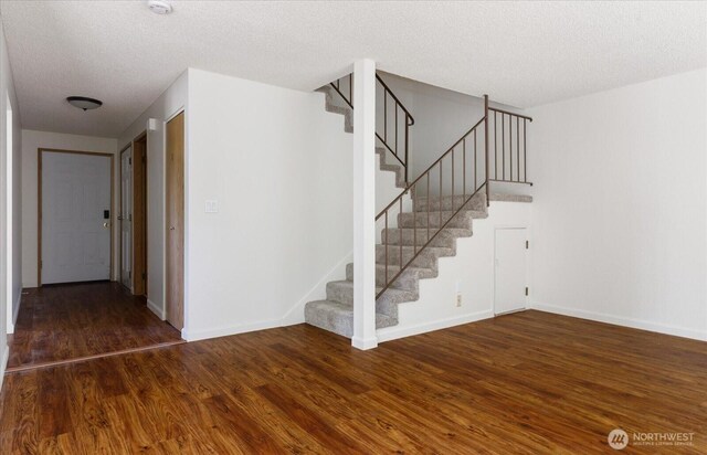 111 NW Columbia Dr Unit B7, Oak Harbor, WA 98277 - stairway featuring wood finished floors, a textured ceiling, and baseboards